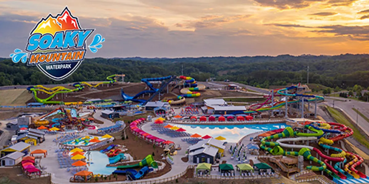 A lively outdoor water park scene featuring water slides, multiple swimming pools, colorful cabanas, and food stalls. Families and children are visible enjoying the various water attractions, capturing a joyful and energetic atmosphere perfect for group fun.